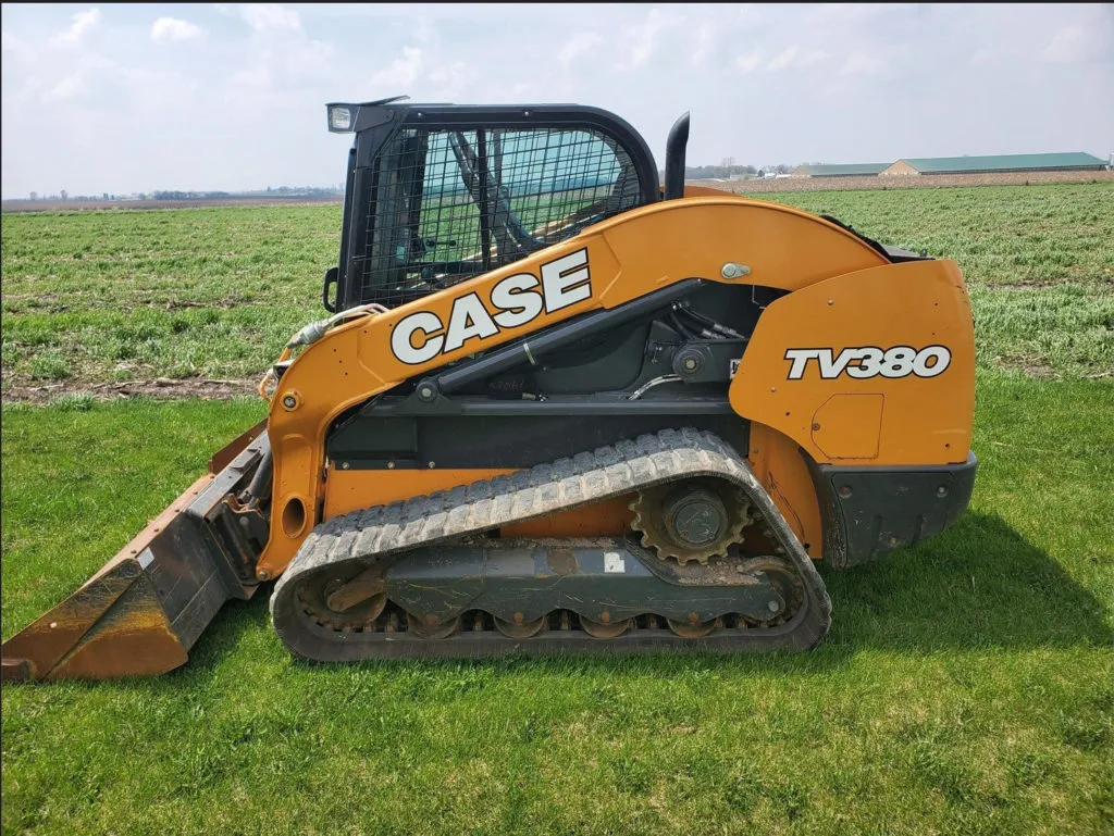 A Case TV380 skid steer parked on a grassy area.